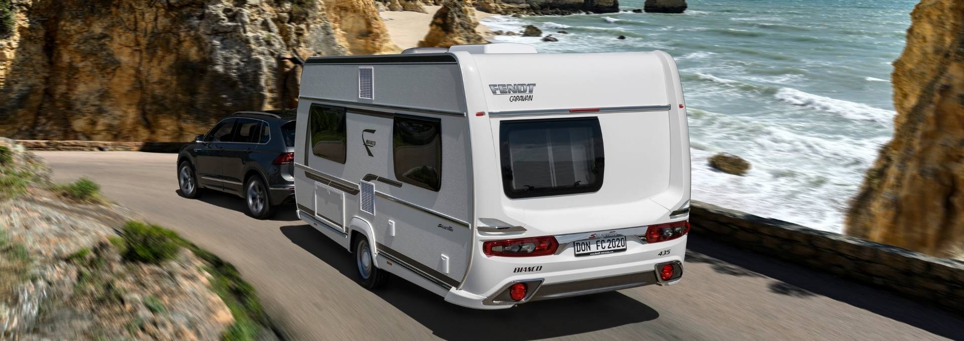 Wohnwagen Bianco Selection von Fendt Caravan auf einer Straße am Meer